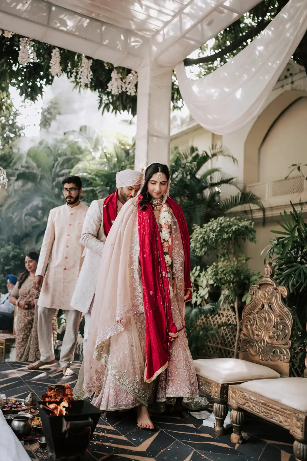 Bride and groom walking around the mandap