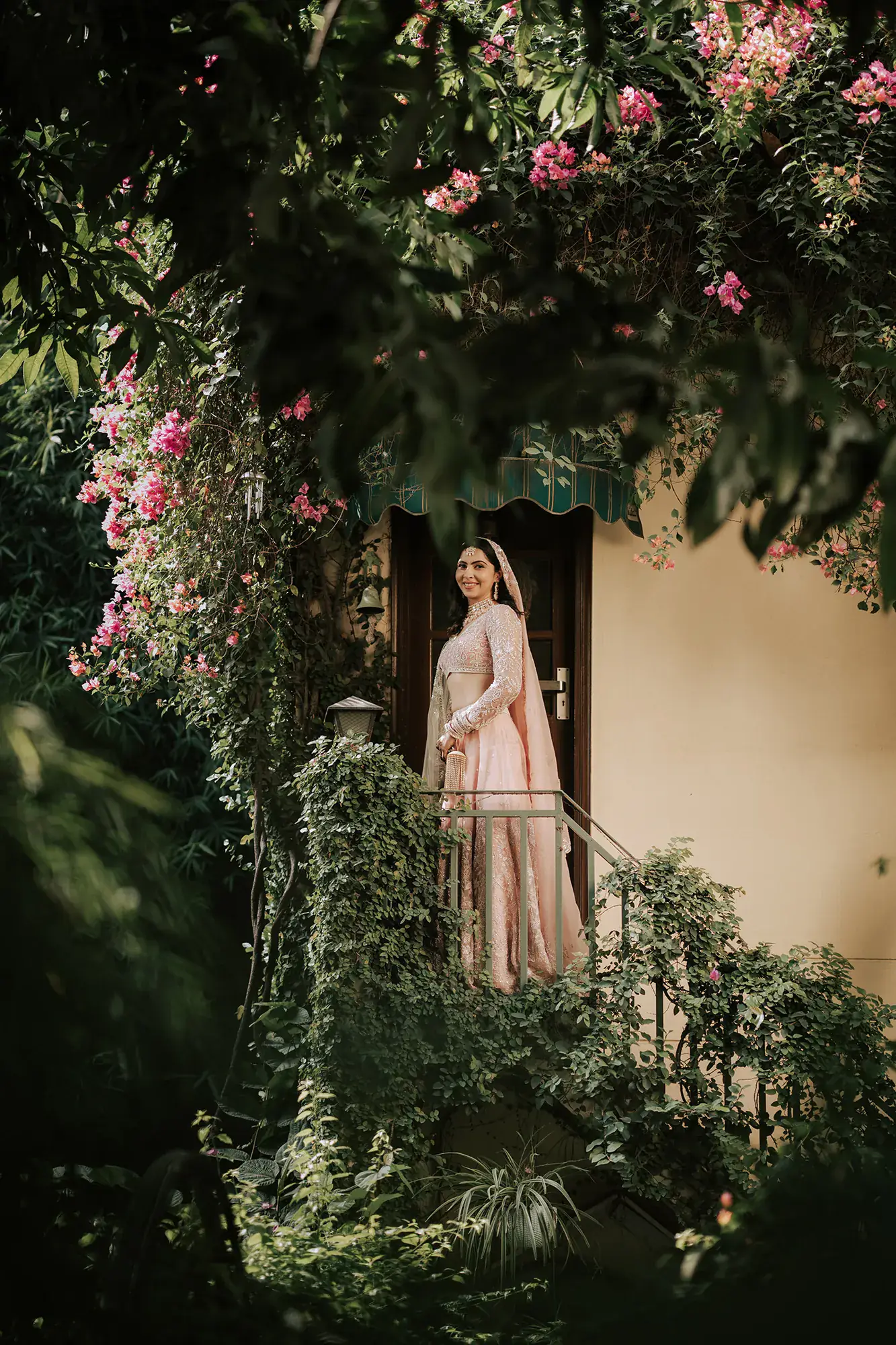 Bride at a doorway framed by bougainvillea
